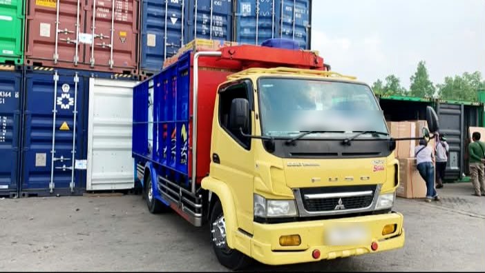 Truk cargo memuat barang pelanggan MSK Express di area peti kemas